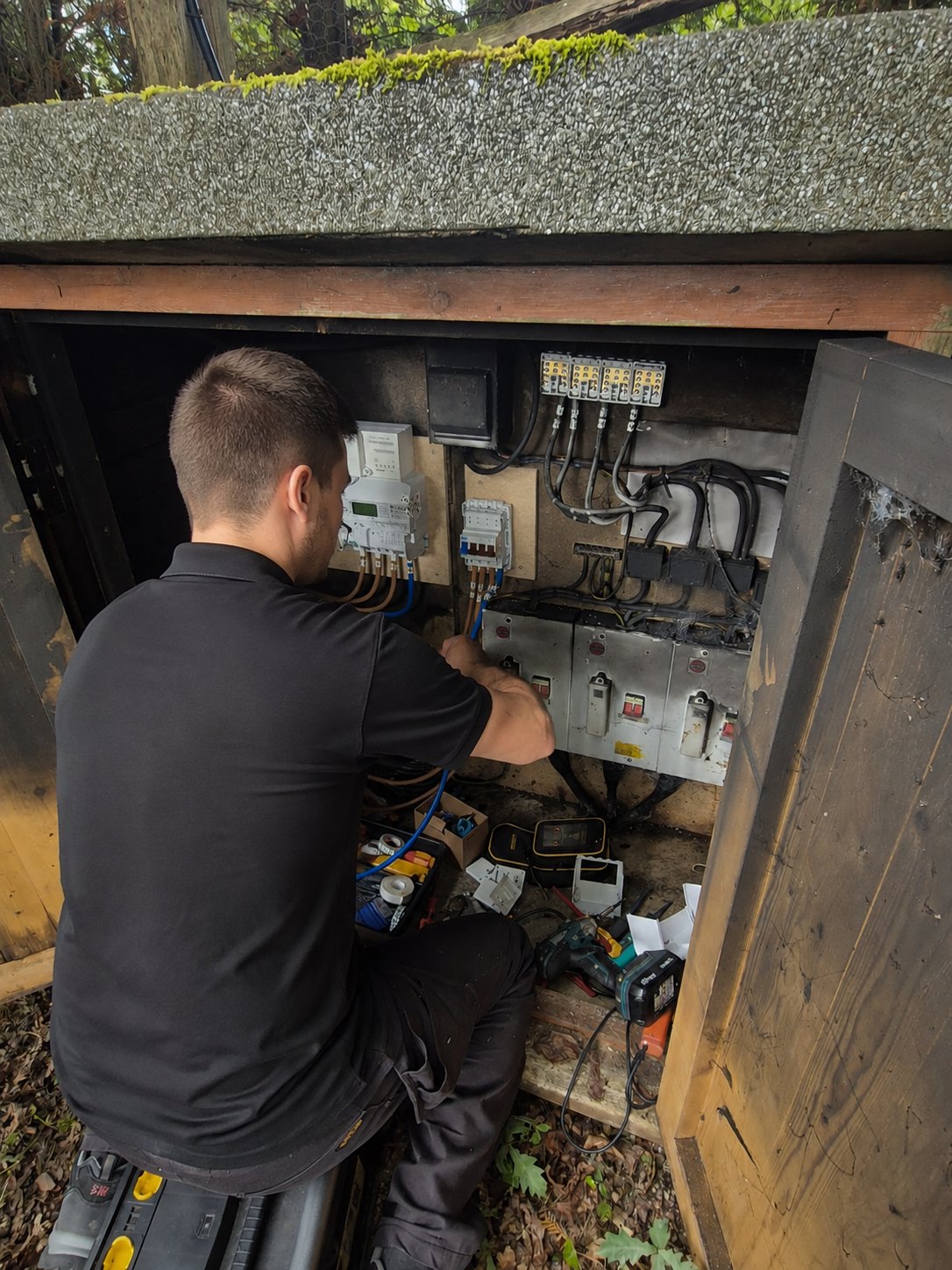 Electrician testing supplies in an outdoor meter cabinet