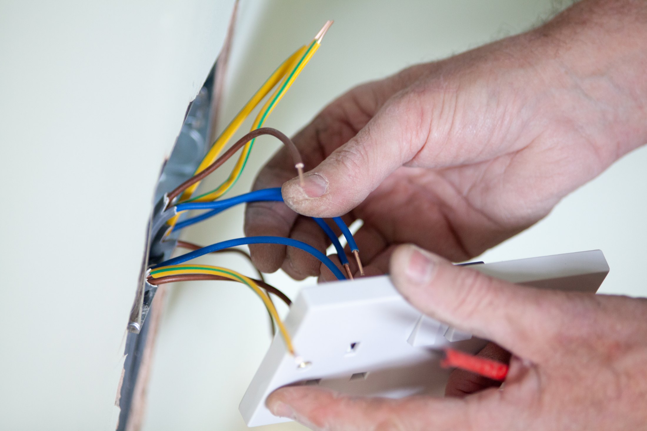 Electrician wiring a new socket faceplate